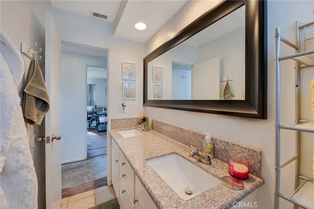 a bathroom with a granite countertop sink a mirror and shower