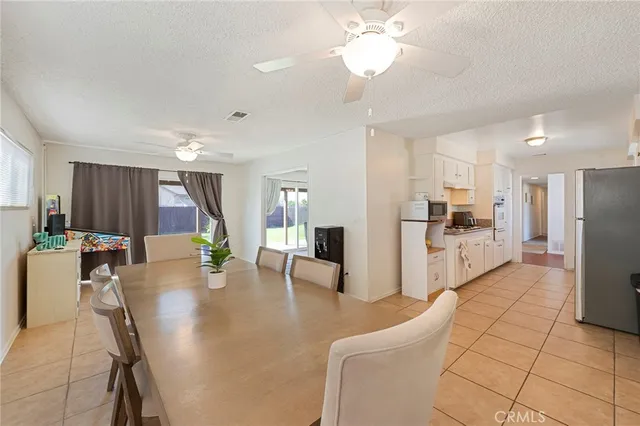 a kitchen with stainless steel appliances refrigerator dining table and chairs
