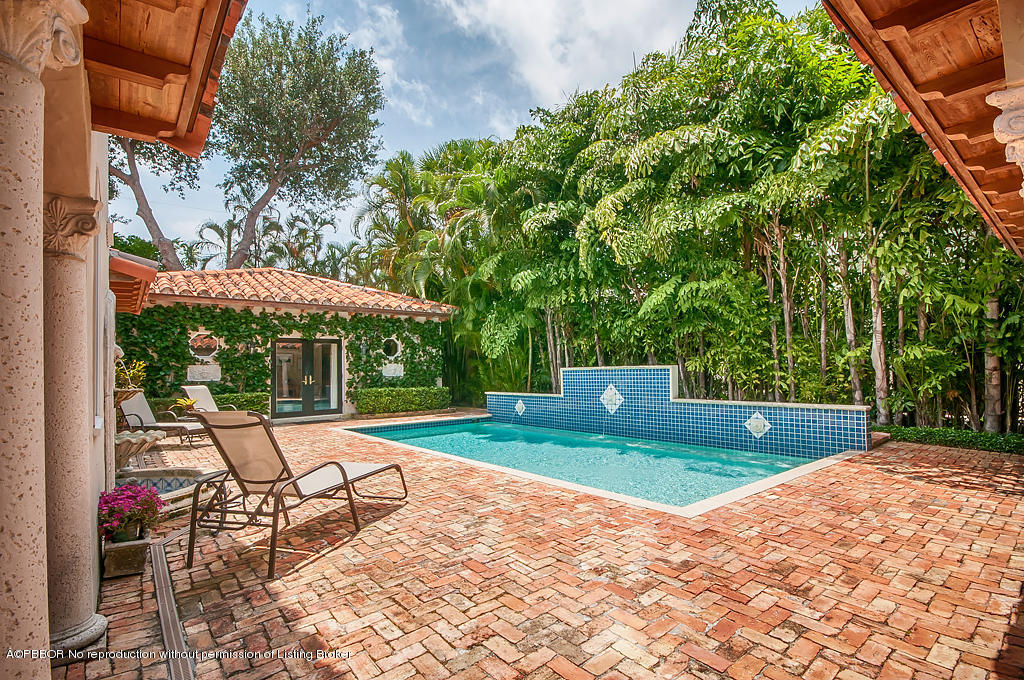 282 Barcelona Road West Palm Beach, FL 33401 - Photo 23 of 32 a view of a backyard with table and chairs under an umbrella