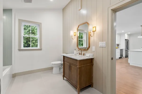 a bathroom with a sink a toilet and mirror