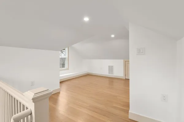 a view of an empty room with wooden floor