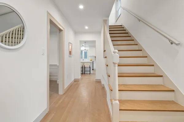 a view of a hallway with wooden floor and entryway