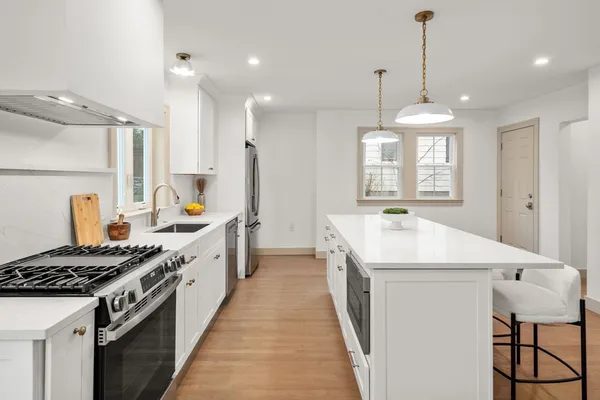 a kitchen that has a sink a stove and a refrigerator