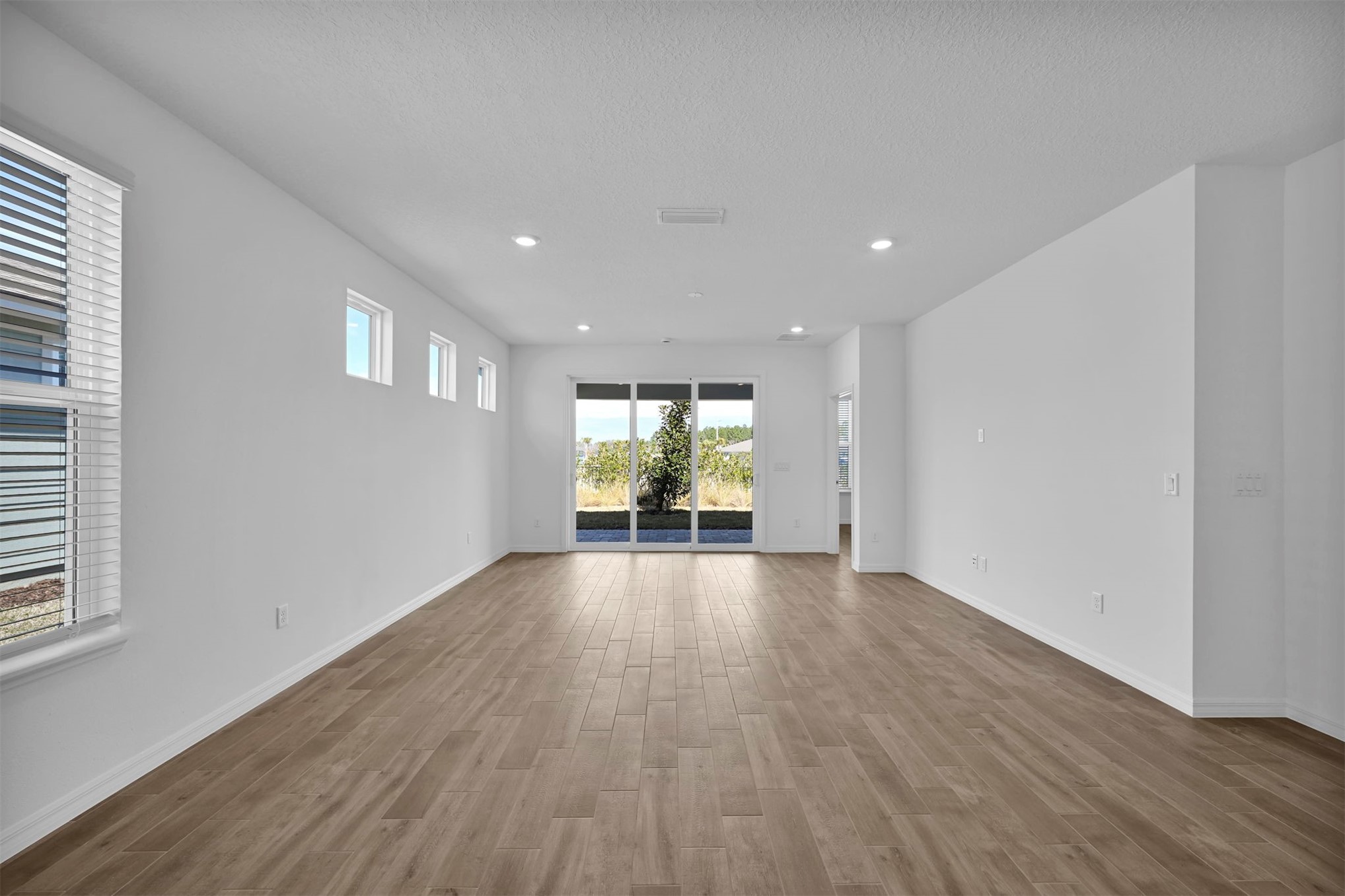 285 Ecliptic Loop Yulee, FL 32097 - Photo 10 of 42 wooden floor in an empty room with a window