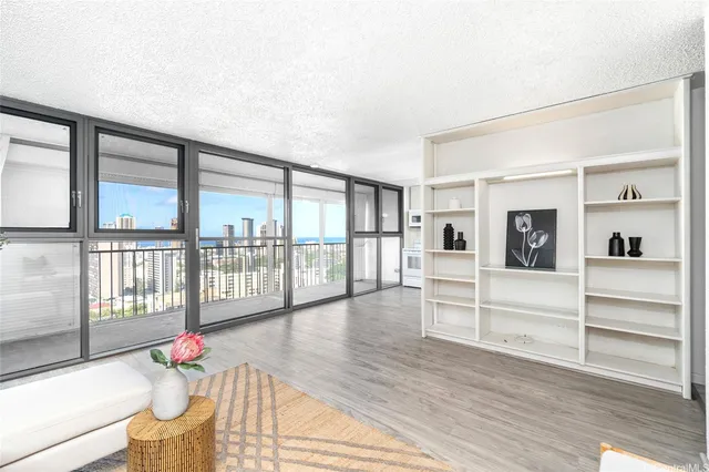 a living room with wooden floor and large windows