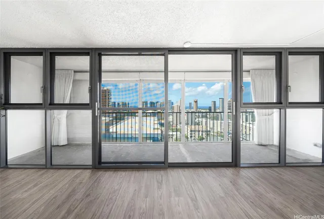 an empty room with wooden floor and windows