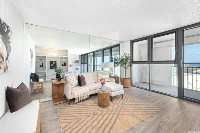 a living room with furniture a large window and wooden floor