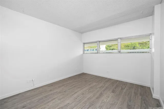 an empty room with wooden floor and window