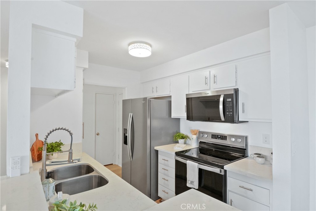 28121 Highridge Road, Unit 402 Rancho Palos Verdes, CA 90275 - Photo 13 of 38 a kitchen with stainless steel appliances a stove microwave and refrigerator