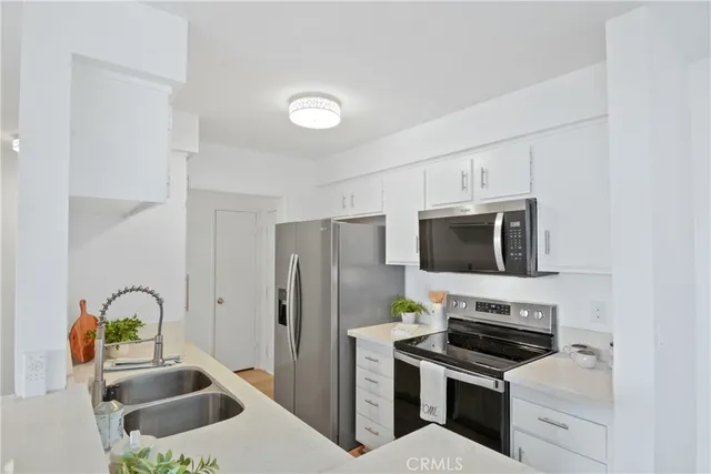 a kitchen with a sink cabinets and appliances