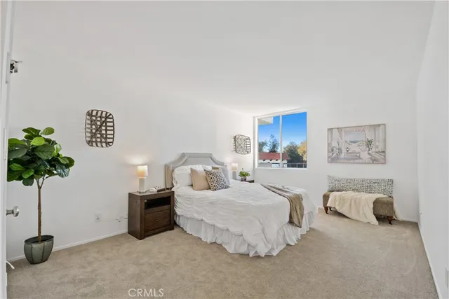 a bedroom with a bed and a potted plant
