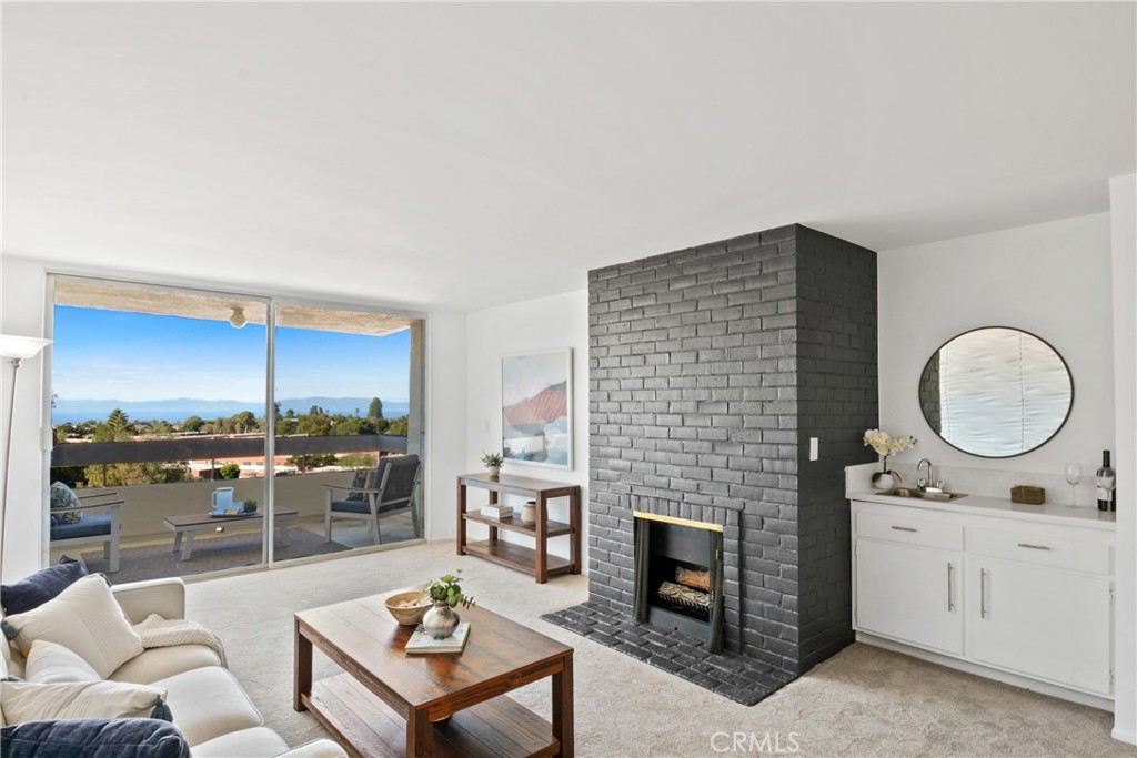 28121 Highridge Road, Unit 402 Rancho Palos Verdes, CA 90275 - Photo 4 of 38 a living room with furniture a fireplace and kitchen view