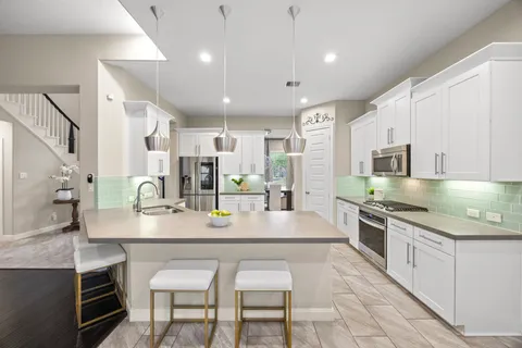 a kitchen with white cabinets and appliances