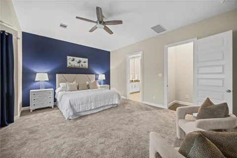a bedroom with a large bed and a chandelier