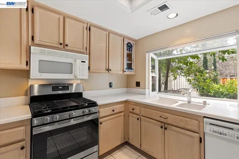 a kitchen with granite countertop white cabinets and appliances