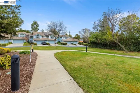 a view of a house with backyard water fountain and sitting area