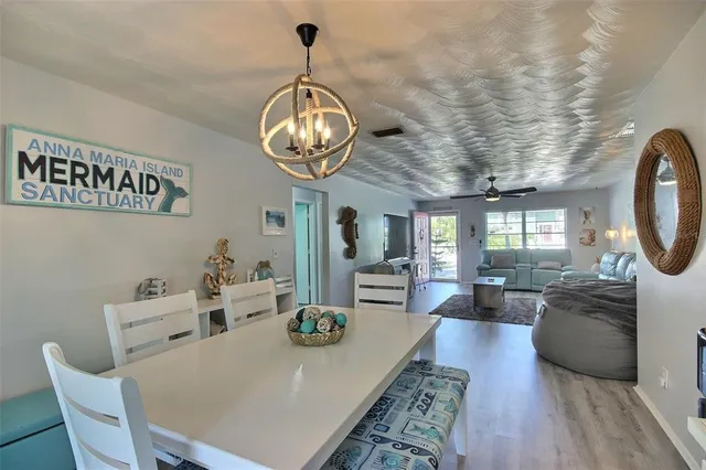 a view of a dining room with furniture a chandelier and wooden floor