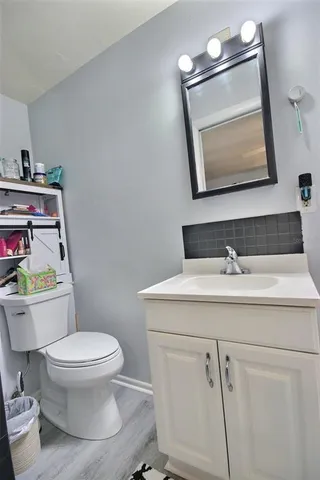 a bathroom with a toilet sink and mirror