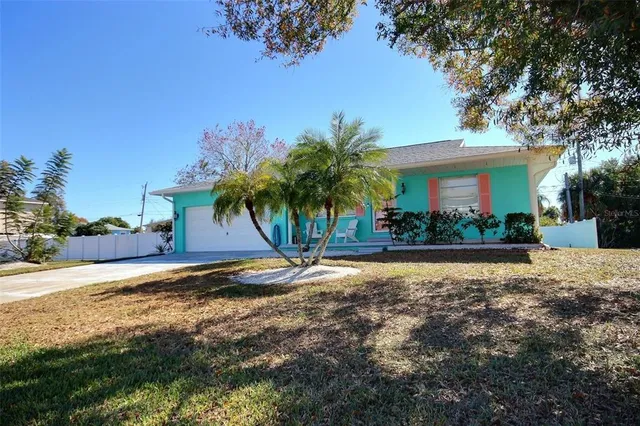 a view of a house with a yard and palm trees