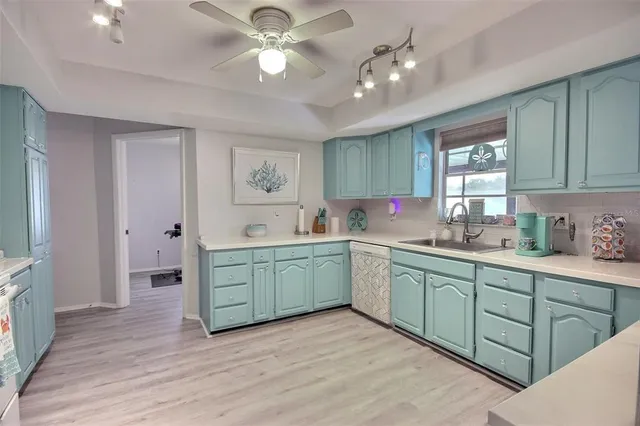 a kitchen with sink cabinets and wooden floor