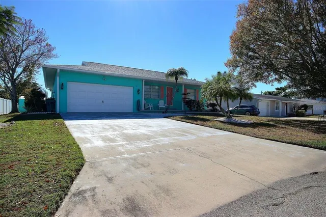 a front view of a house with a yard and palm trees