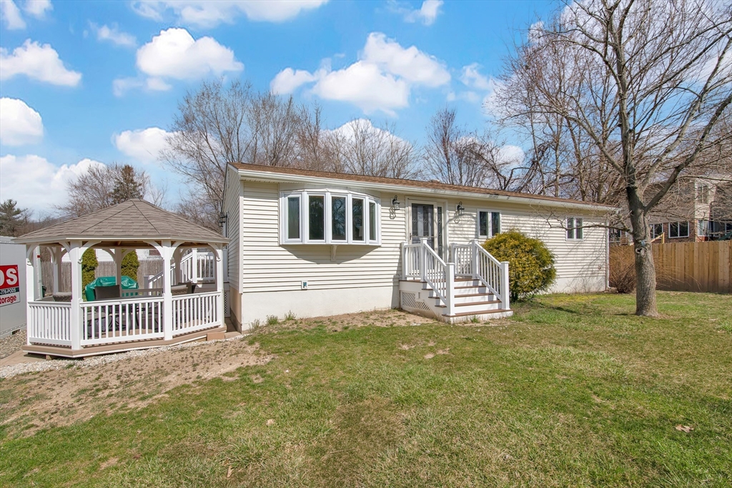 a view of a house with backyard and a tree