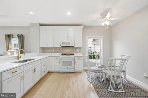 a kitchen with a sink dishwasher a stove a dining table and chairs