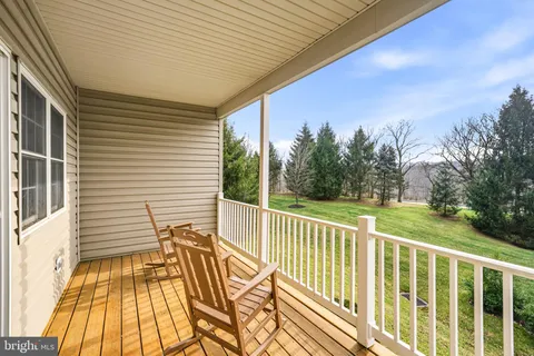a view of a balcony with wooden floor and fence