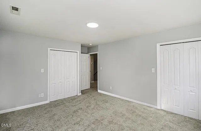 a view of an empty room and closet area