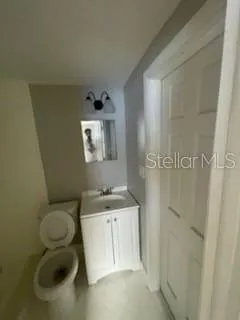 a bathroom with a granite countertop toilet sink and mirror