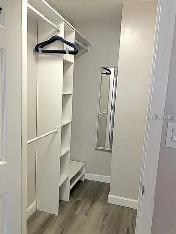 an empty room with wooden floor and a ceiling fan