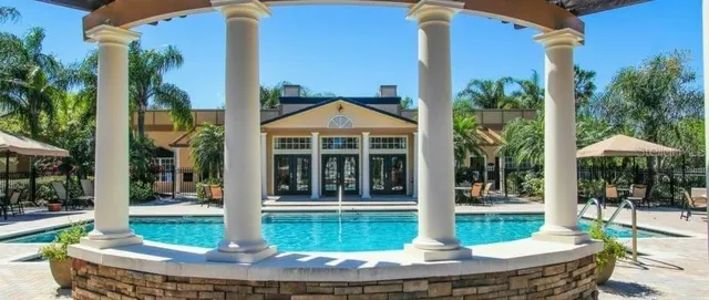 a front view of a house with swimming pool having outdoor seating