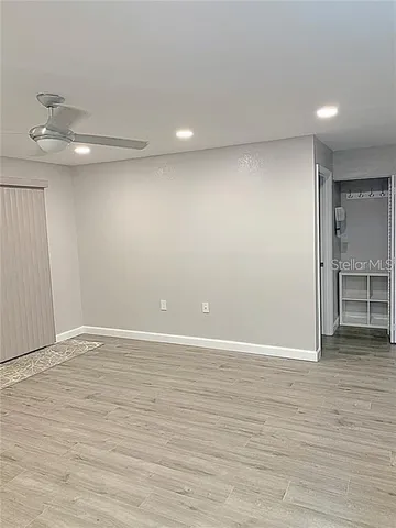 a view of an empty room with wooden floor