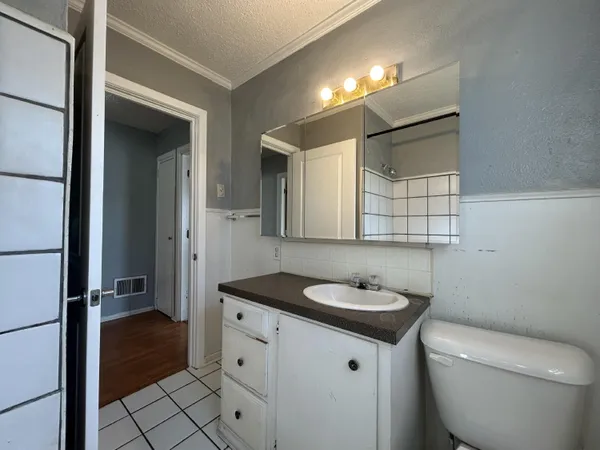 a bathroom with a granite countertop sink a toilet and a mirror