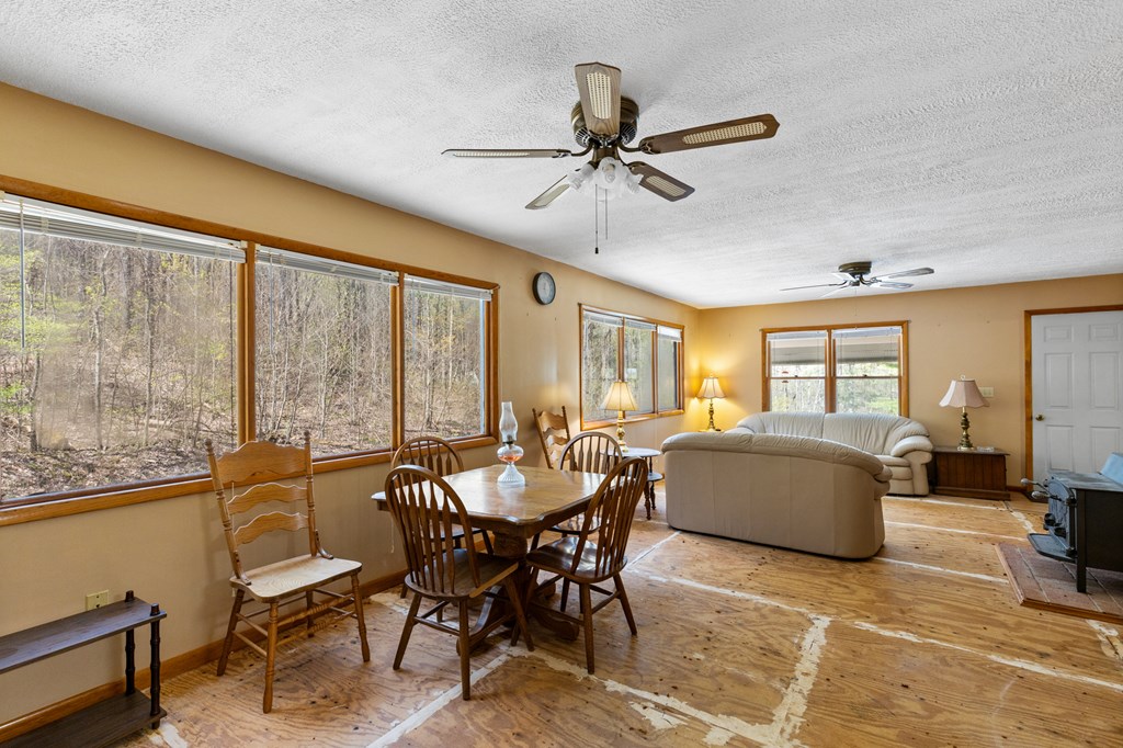 65 Caldwell Mountain Road Suches, GA 30572 - Photo 4 of 38 a dining room with furniture a flat screen tv and a large window