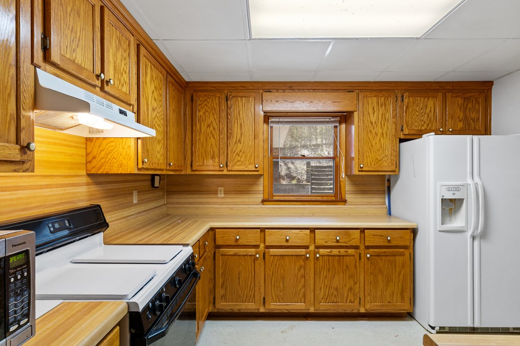 65 Caldwell Mountain Road Suches, GA 30572 - Photo 10 of 38 a kitchen with a refrigerator and a more cabinets