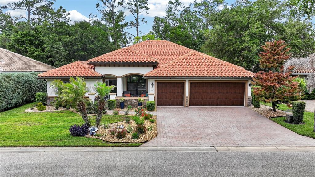 77 Apian Way Ormond Beach, FL 32174 - Photo 1 of 35 a front view of a house with a garden and plants