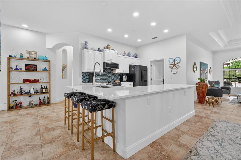 77 Apian Way Ormond Beach, FL 32174 - Photo 11 of 35 a kitchen with stainless steel appliances kitchen island granite countertop a refrigerator and a sink