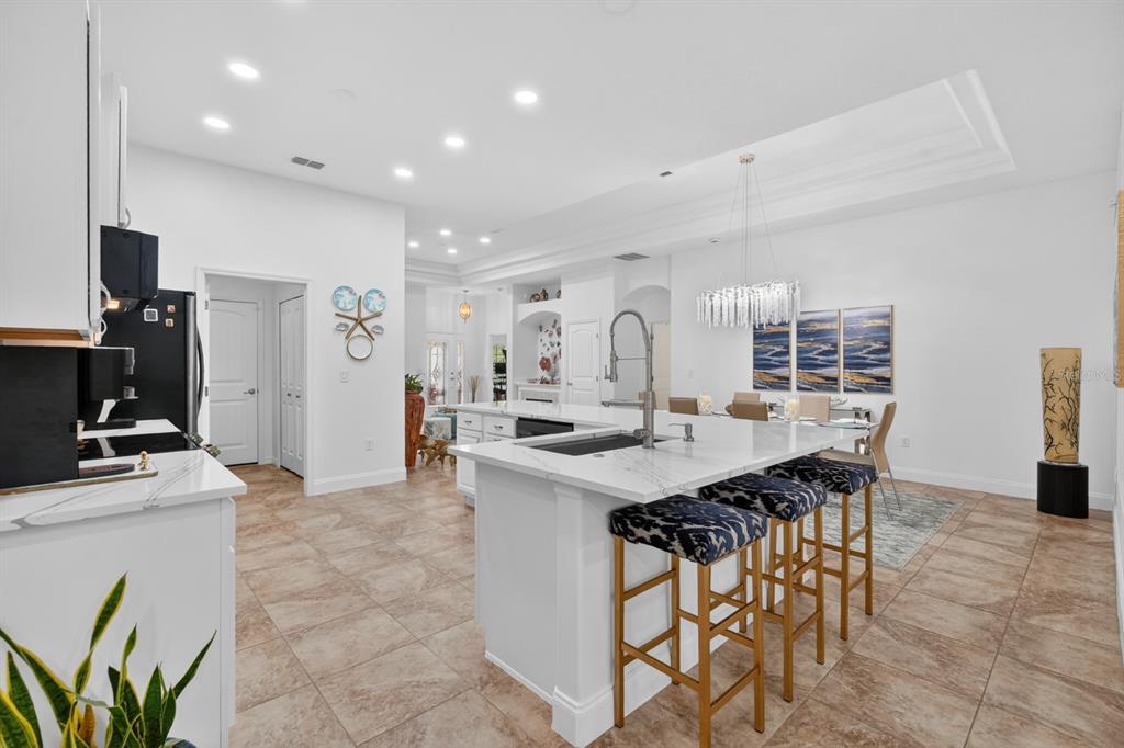 77 Apian Way Ormond Beach, FL 32174 - Photo 12 of 35 a kitchen with kitchen island a sink table and chairs