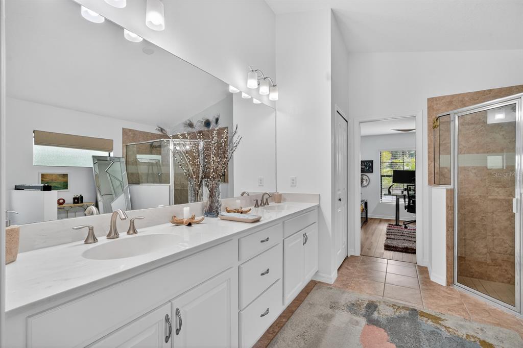 77 Apian Way Ormond Beach, FL 32174 - Photo 16 of 35 a spacious en suite bathroom with double sink and a large mirror