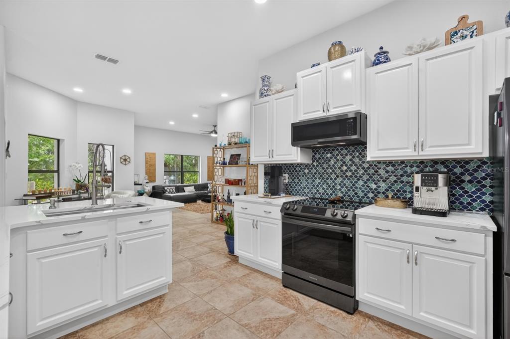 77 Apian Way Ormond Beach, FL 32174 - Photo 8 of 35 a kitchen with white cabinets and appliances