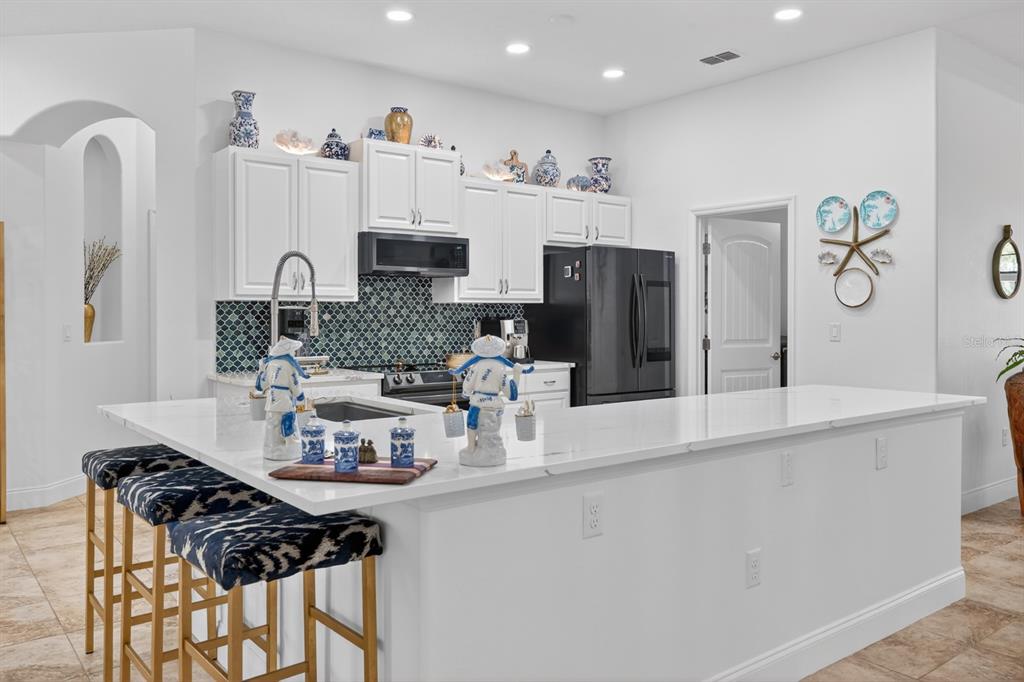 77 Apian Way Ormond Beach, FL 32174 - Photo 10 of 35 a kitchen with stainless steel appliances a sink a stove a refrigerator and cabinets