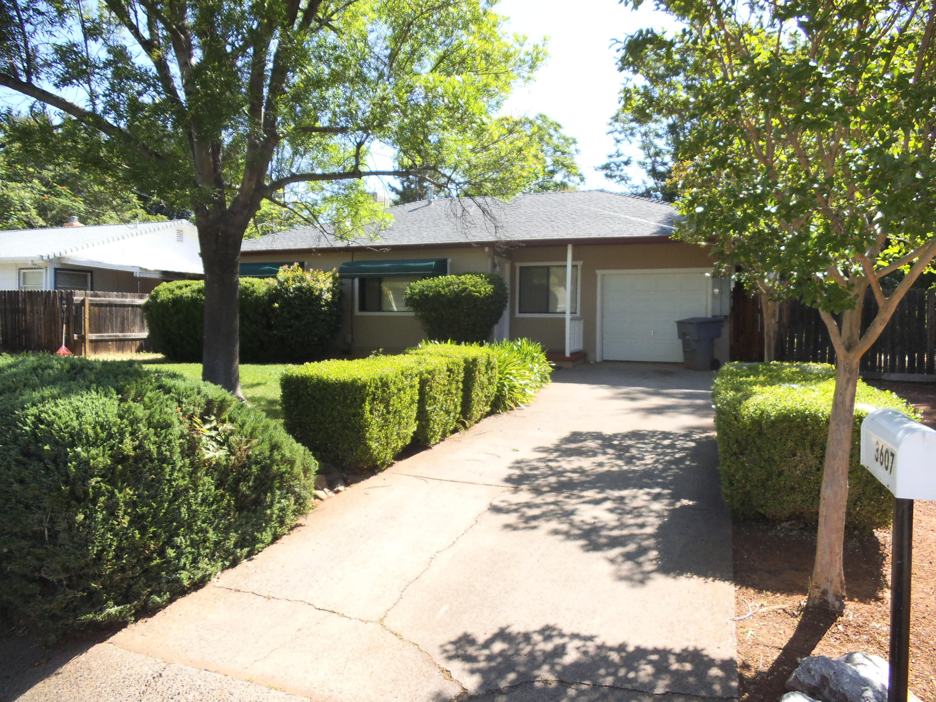3607 Ricardo Avenue Redding, CA 96002 - Photo 2 of 20 a front view of a house with a yard and potted plants