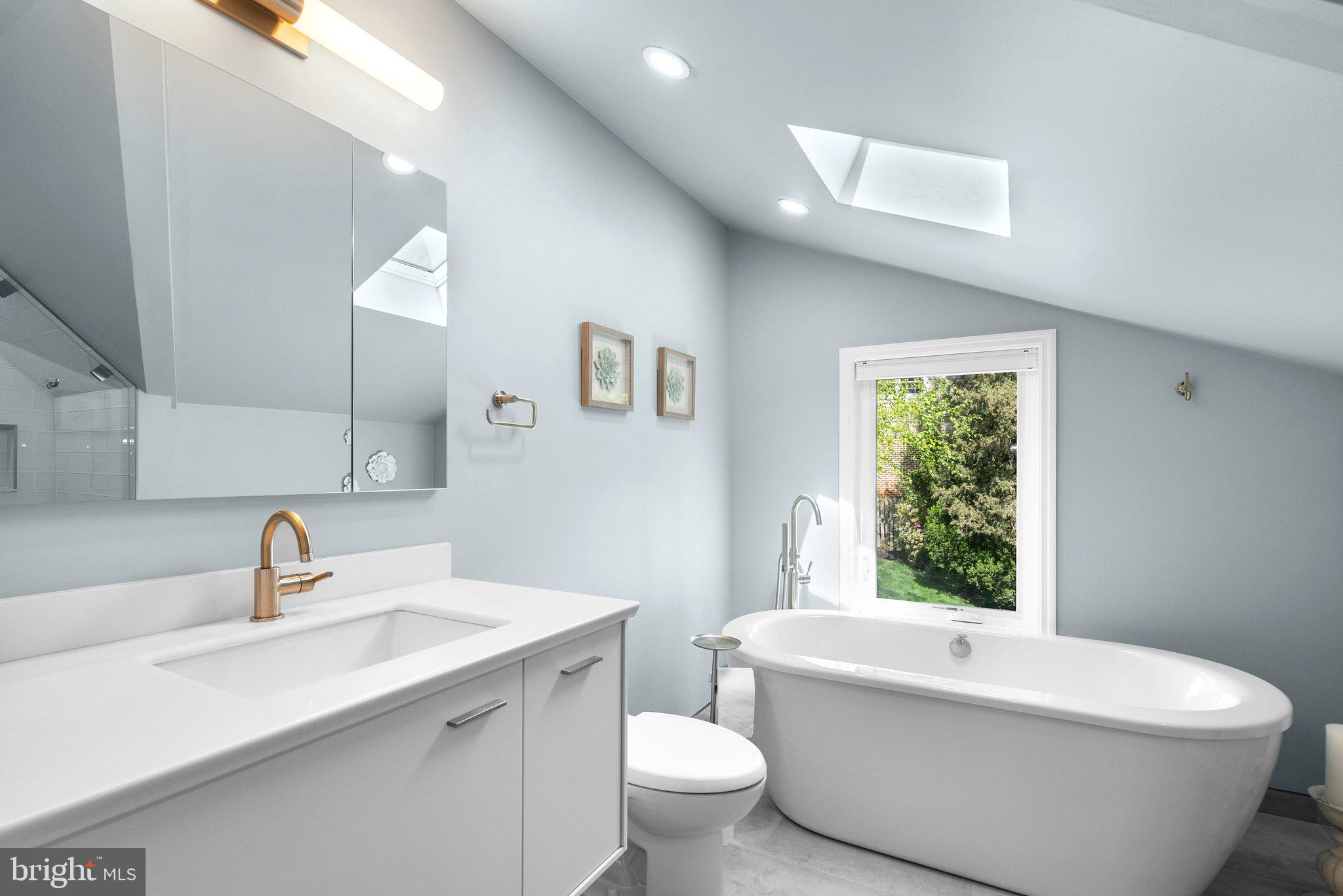 507 Ellsworth Drive Silver Spring, MD 20910 - Photo 25 of 42 a bathroom with a white tub a sink and a large mirror