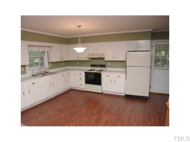 8416 Azalea Place Raleigh, NC 27613 - Photo 2 of 12 a kitchen with stainless steel appliances a sink cabinets and a wooden floor