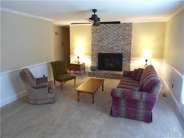 8416 Azalea Place Raleigh, NC 27613 - Photo 3 of 12 a living room with furniture and a fireplace