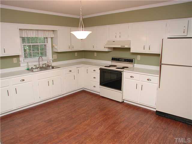 8416 Azalea Place Raleigh, NC 27613 - Photo 7 of 12 a kitchen with granite countertop white cabinets and white appliances