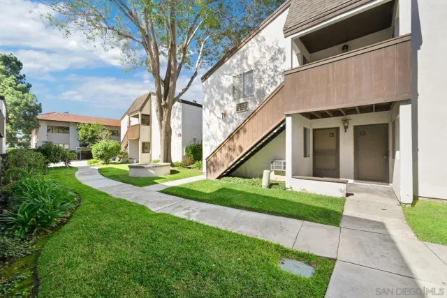 a view of a house with a yard and potted plants