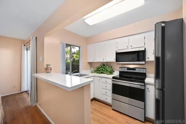 a kitchen with white cabinets and appliances