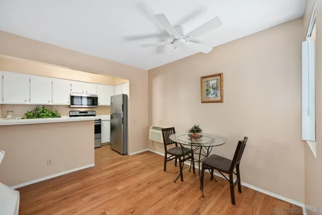 a kitchen with a table chairs refrigerator and cabinets